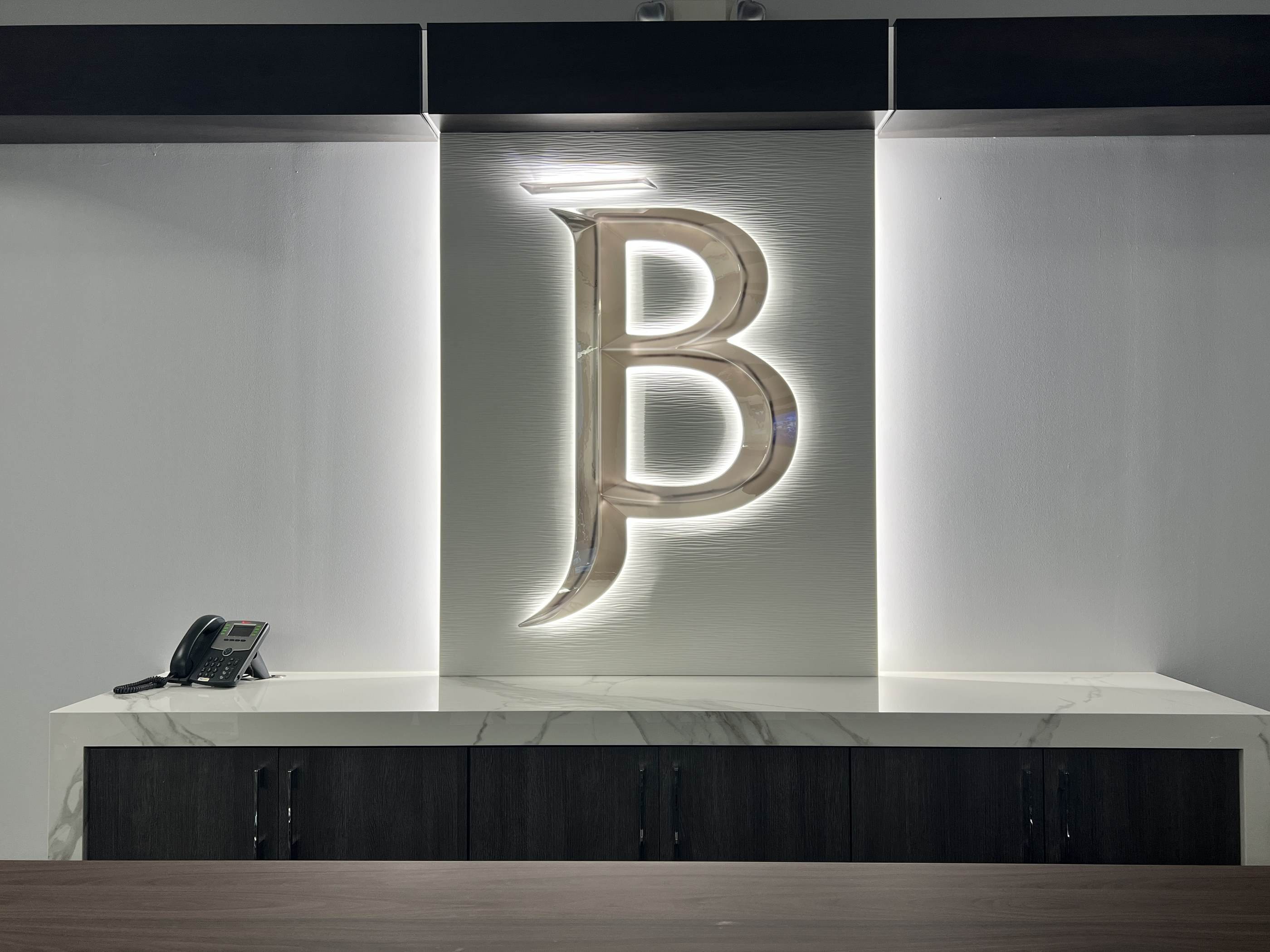 Polished JB monogram on a textured white wall